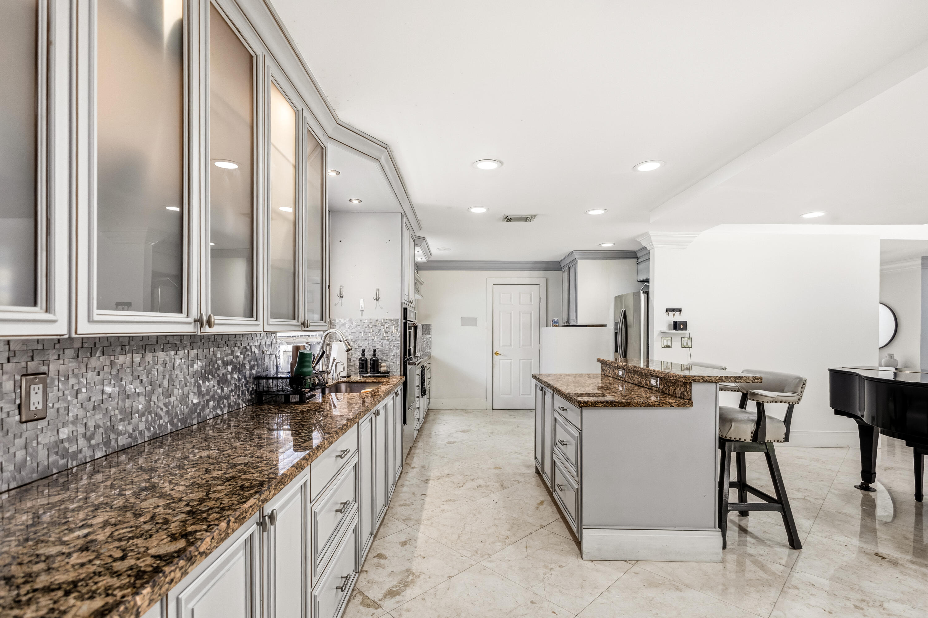 5223 Deerhurst Crescent Circle Boca Raton, FL 33486 - Photo 26 of 51 a kitchen with stainless steel appliances granite countertop a sink and a refrigerator