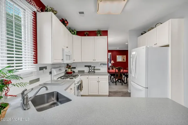 a kitchen that has a lot of white cabinets and a dishwasher