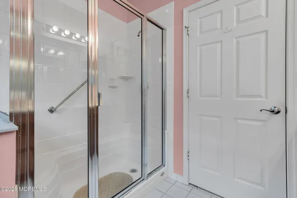 an empty room with ceiling fan and windows
