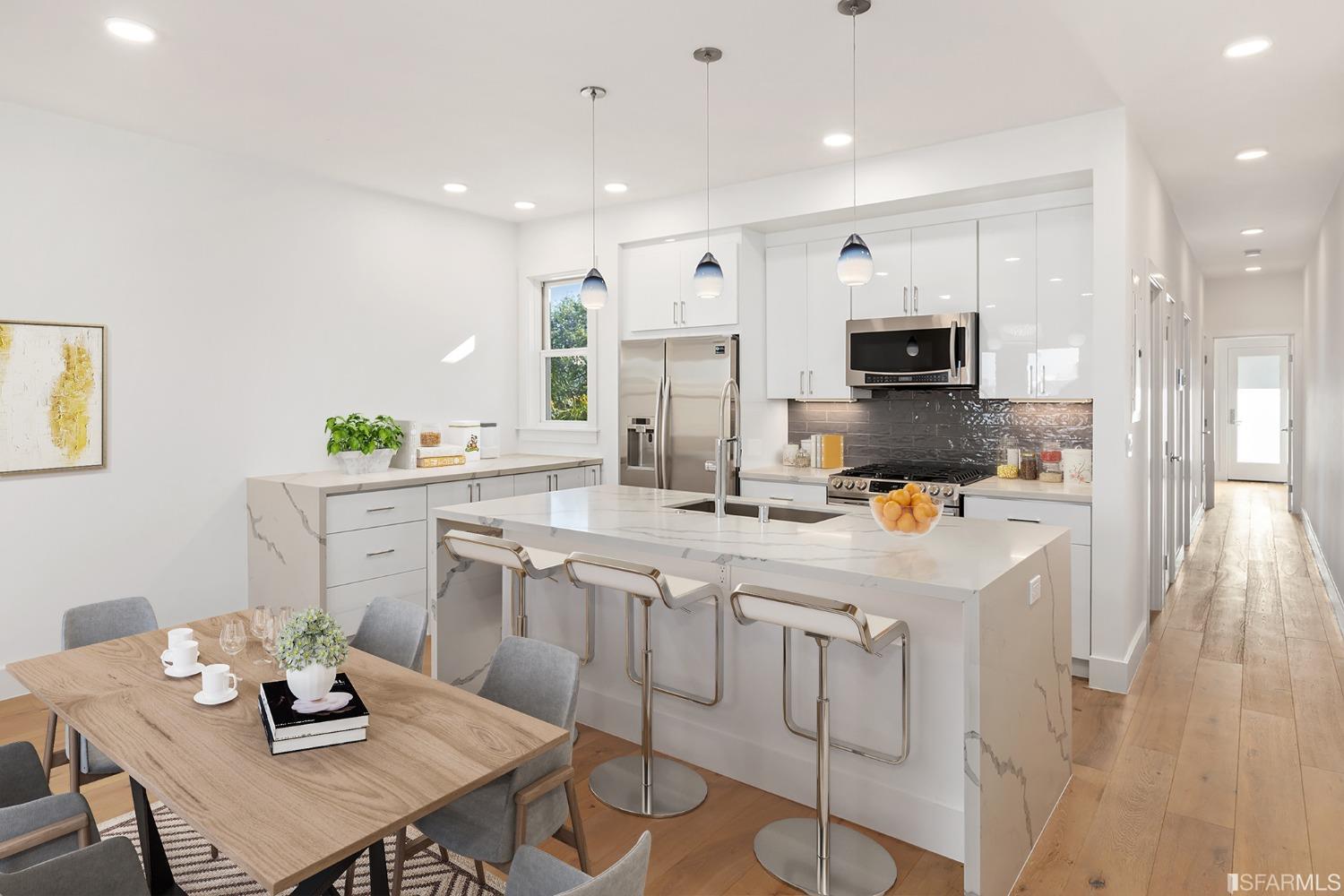 a kitchen with white cabinets stainless steel appliances and dining table