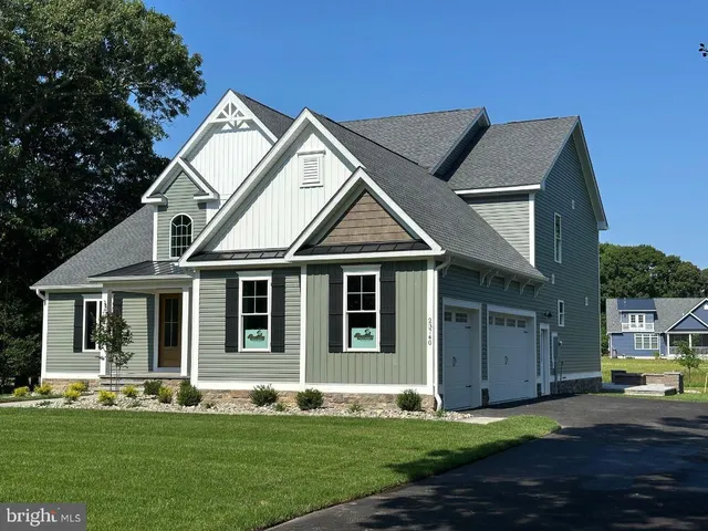 a front view of a house with a garden and yard
