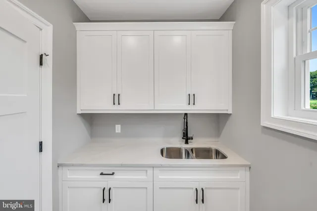 a kitchen with white cabinets and a sink