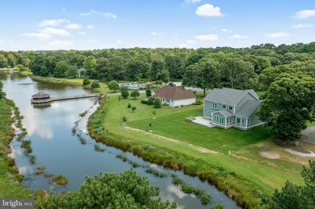 an aerial view of a house with a yard and lake view