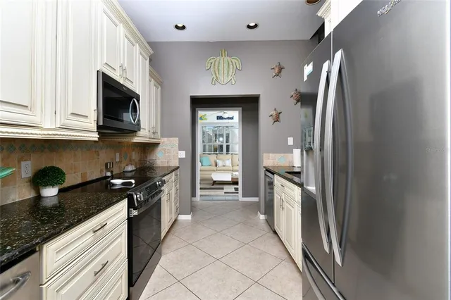 a large kitchen with stainless steel appliances granite countertop a stove and a refrigerator