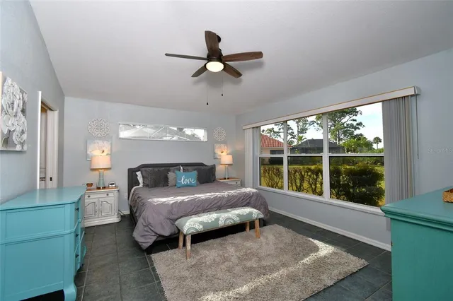a bedroom with a bed and a large window