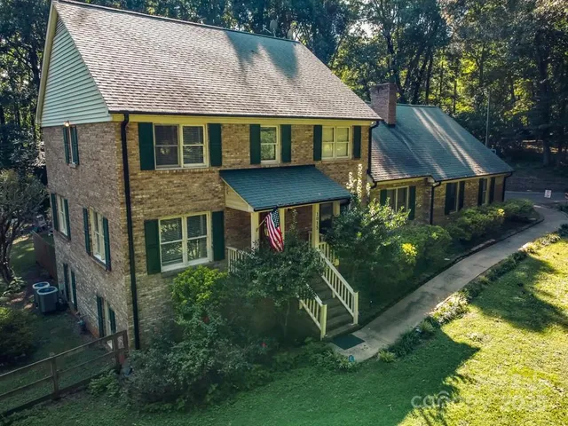 a aerial view of a house next to a yard with plants and a fountain
