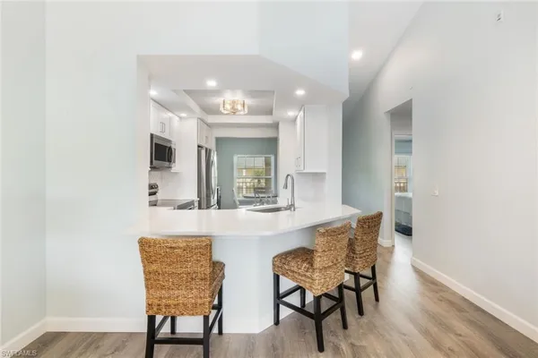 a view of a kitchen area with furniture and wooden floor