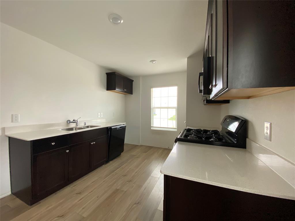 5911 Nyquist Way Forney, TX 75126 - Photo 8 of 38 a kitchen with a sink a stove and cabinets