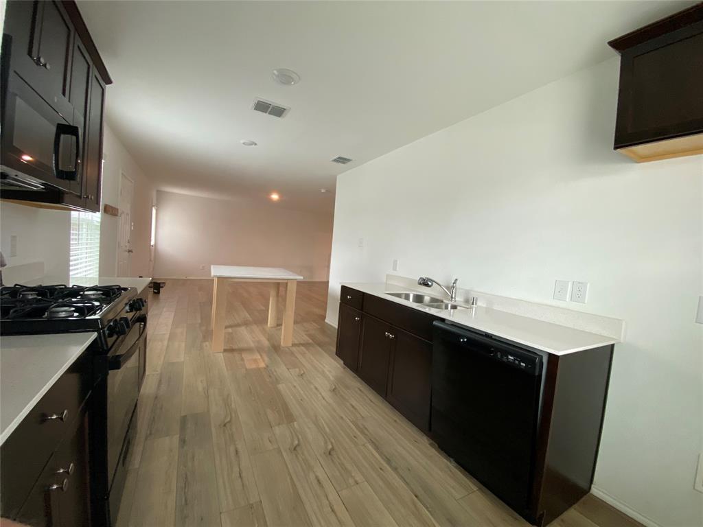 5911 Nyquist Way Forney, TX 75126 - Photo 9 of 38 a kitchen with stainless steel appliances granite countertop a stove a sink and a microwave