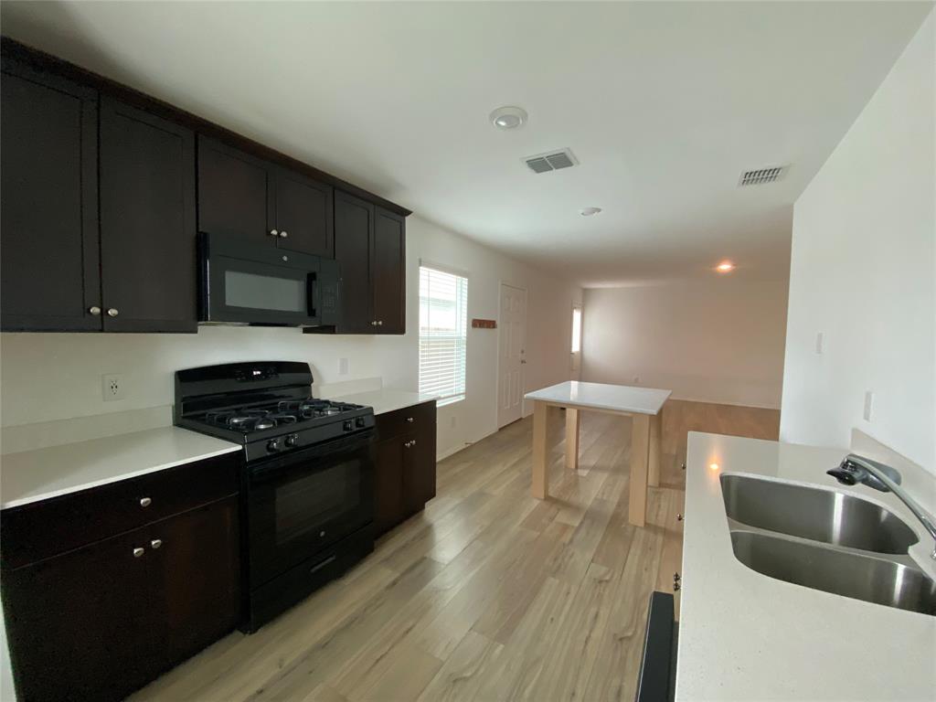 5911 Nyquist Way Forney, TX 75126 - Photo 10 of 38 a kitchen with granite countertop a stove and a sink
