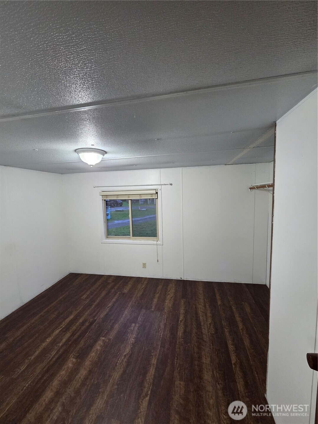 10531 176th Avenue Southwest, Unit 6 Rochester, WA 98579 - Photo 15 of 24 a view of an empty room with wooden floor and a window
