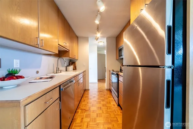 a kitchen with stainless steel appliances a sink a stove and cabinets