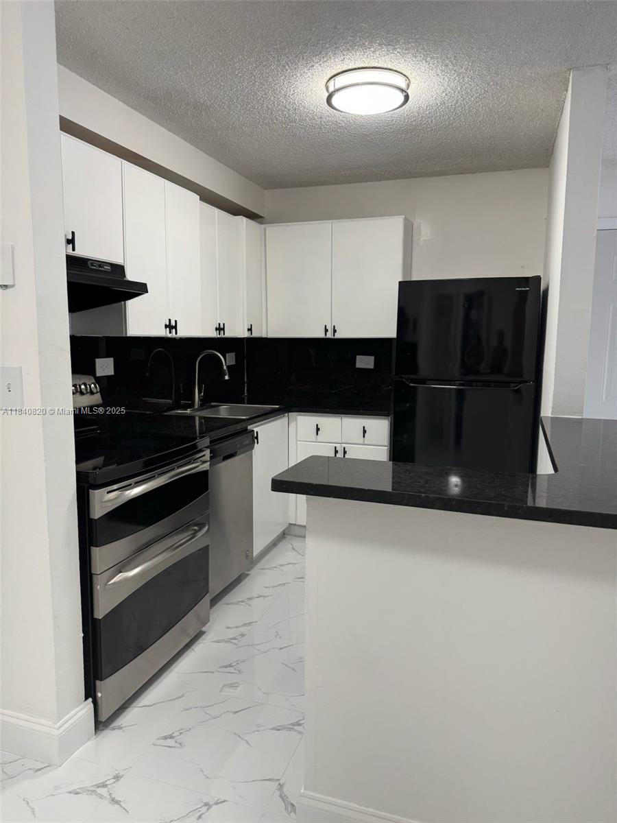 a kitchen with a refrigerator and a stove top oven