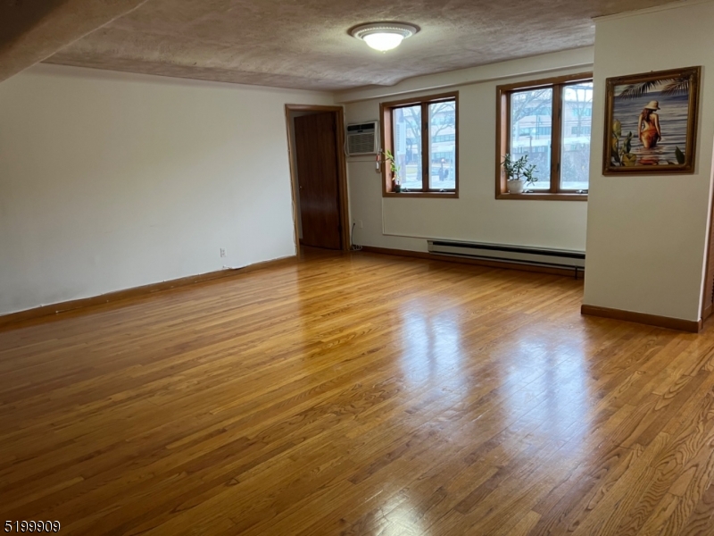351 Springfield Avenue, Unit 3 Summit, NJ 07901 - Photo 3 of 6 a view of an empty room with wooden floor and a window