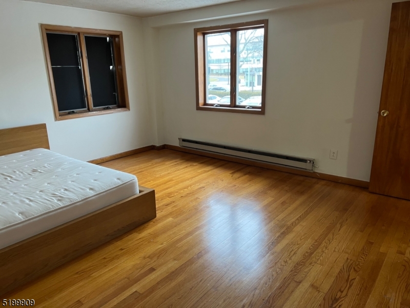 351 Springfield Avenue, Unit 3 Summit, NJ 07901 - Photo 4 of 6 an empty room with wooden floor and window