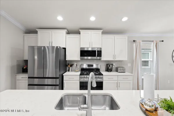 a kitchen with stainless steel appliances granite countertop a refrigerator sink and stove