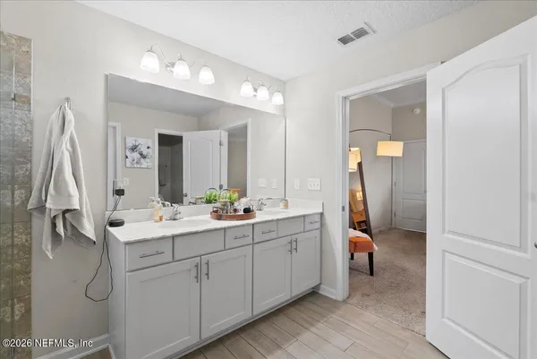 a en suite bathroom with a double vanity sink and a mirror