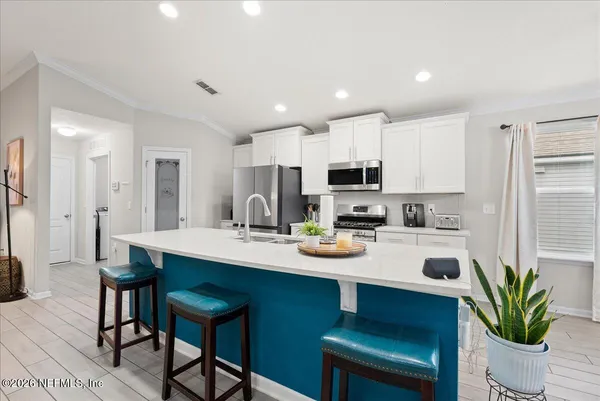 a kitchen with a table a refrigerator and cabinets