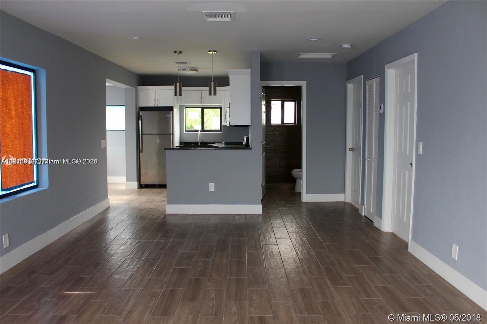107 West Pembroke Road Hallandale Beach, FL 33009 - Photo 4 of 7 an empty room with wooden floor and windows