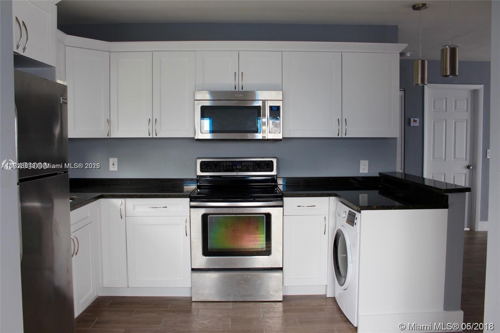 107 West Pembroke Road Hallandale Beach, FL 33009 - Photo 5 of 7 a kitchen with a stove and a microwave