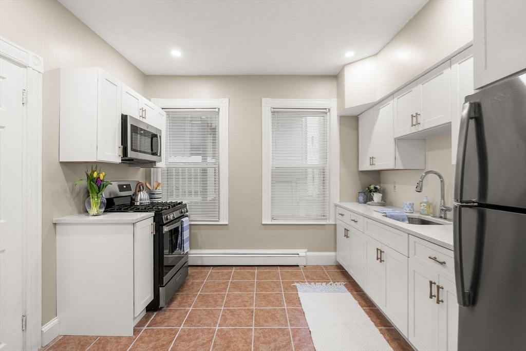 3 Spring Garden Street, Unit 1 Boston, MA 02125 - Photo 4 of 23 a kitchen with stainless steel appliances a stove refrigerator sink and cabinets