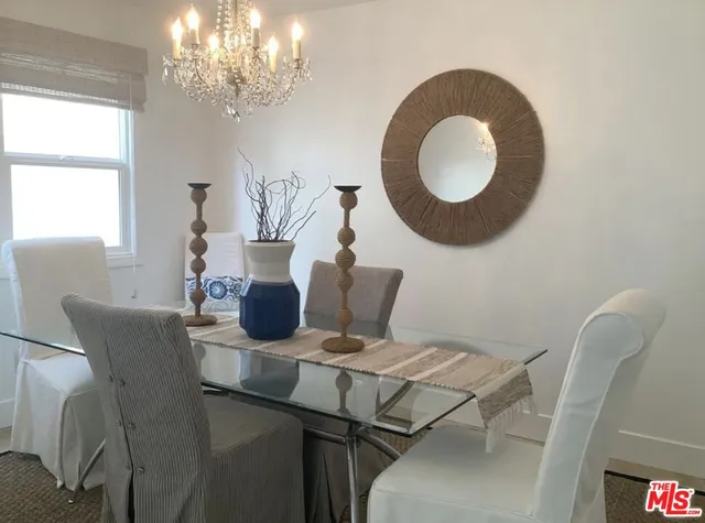 a dining room with furniture a chandelier and window