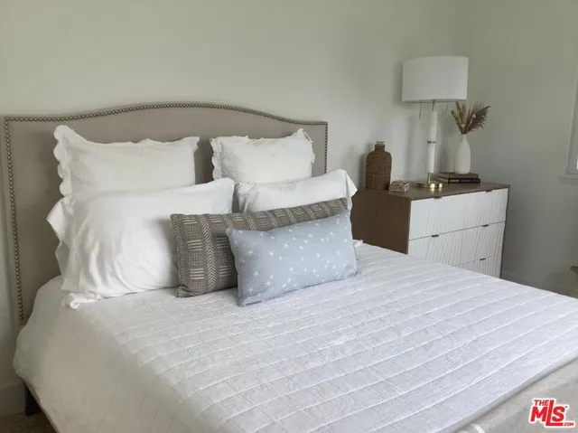 a large bed sitting in a bedroom and lamp