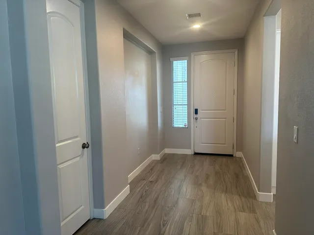 a view of a big room with wooden floor and windows