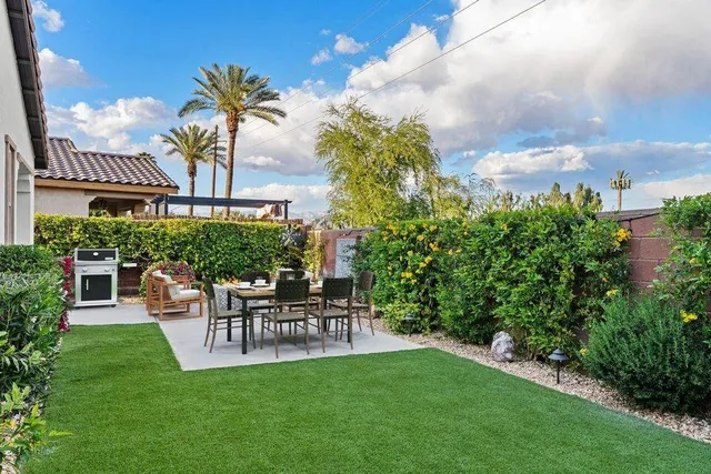 a view of a swimming pool with lawn chairs under an umbrella