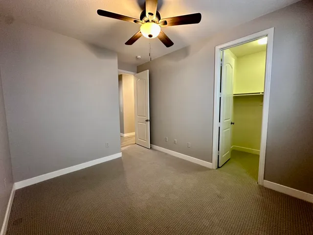 an empty room with a window and a fan