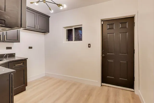 a view of an empty room with wooden floor and cabinets