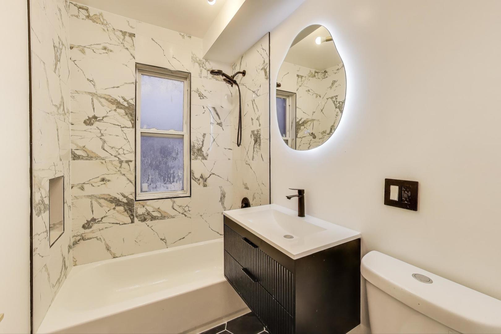 1117 West 57th Street Chicago, IL 60621 - Photo 17 of 24 a bathroom with a sink mirror toilet and bathtub