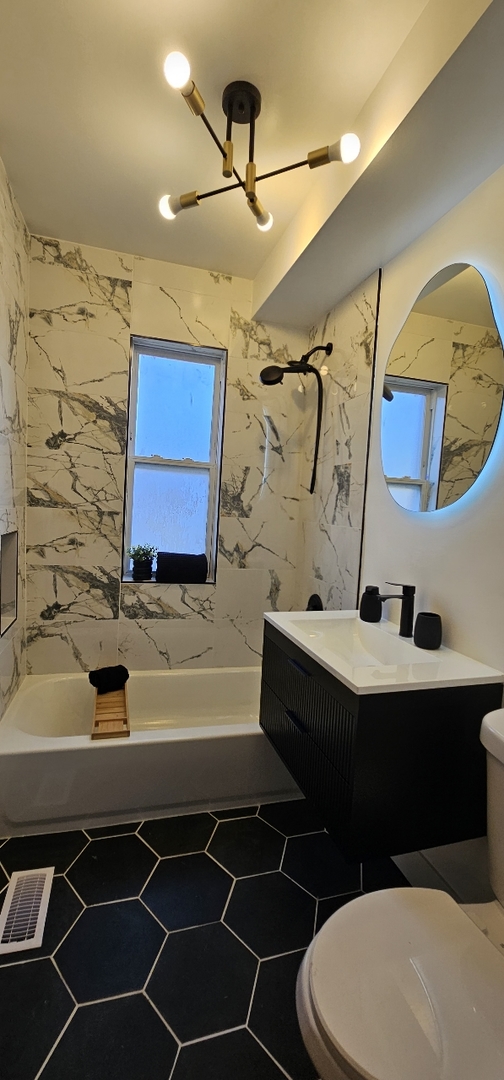 1117 West 57th Street Chicago, IL 60621 - Photo 6 of 24 a bathroom with a sink vanity mirror bathtub and toilet