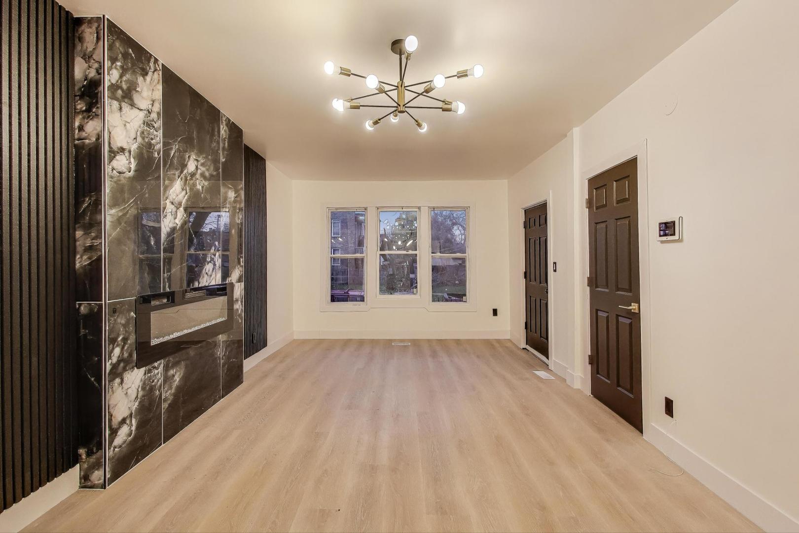1117 West 57th Street Chicago, IL 60621 - Photo 7 of 24 a view of an empty room with a window and wooden floor