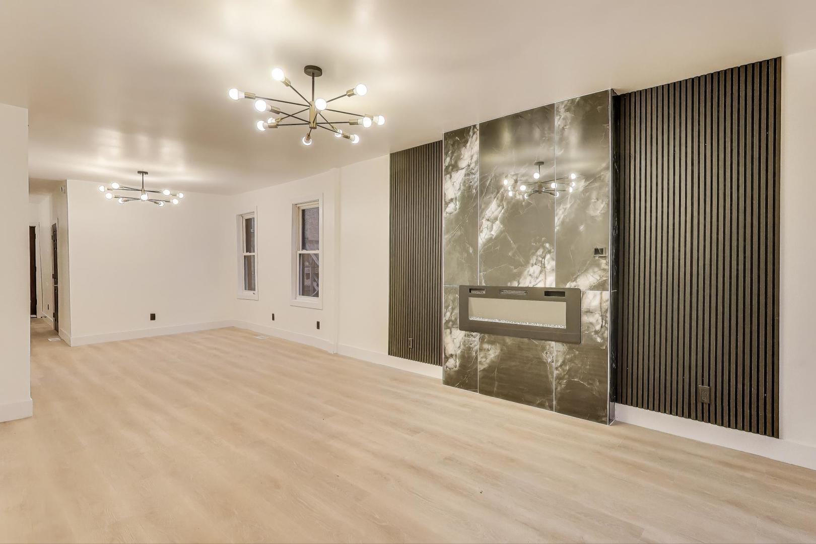 1117 West 57th Street Chicago, IL 60621 - Photo 8 of 24 a view of a livingroom with a chandelier fan and wooden floor