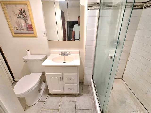 a bathroom with a toilet a sink and a mirror