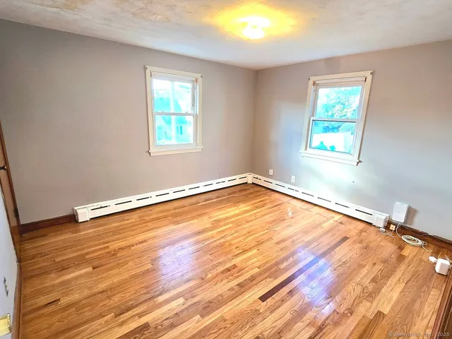 a view of a room with wooden floor and window
