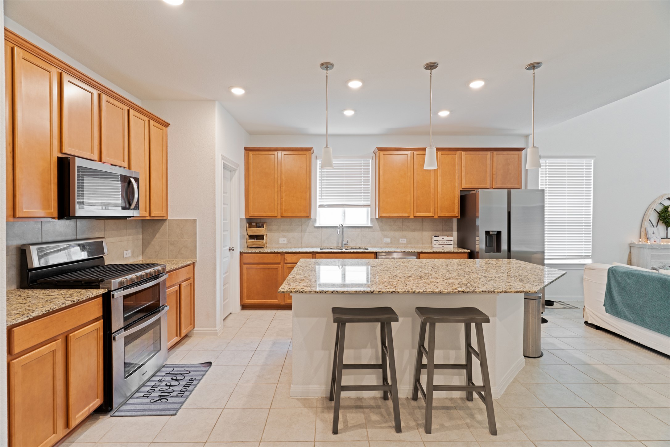 237 Rain Lily Lane Georgetown, TX 78626 - Photo 10 of 20 a kitchen with stainless steel appliances granite countertop wooden cabinets a stove a sink a dining table and chairs