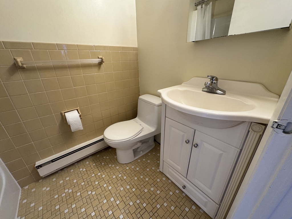 1691 Cambridge Street, Unit 42 Cambridge, MA 02138 - Photo 10 of 16 a bathroom with a sink a toilet and mirror