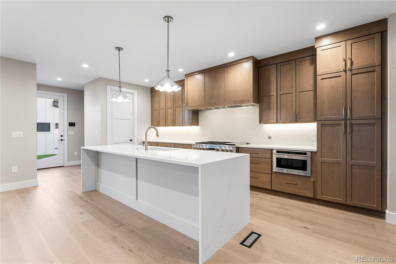 4494 Meade Street Denver, CO 80211 - Photo 5 of 36 a open kitchen with stainless steel appliances granite countertop a stove a sink and a refrigerator