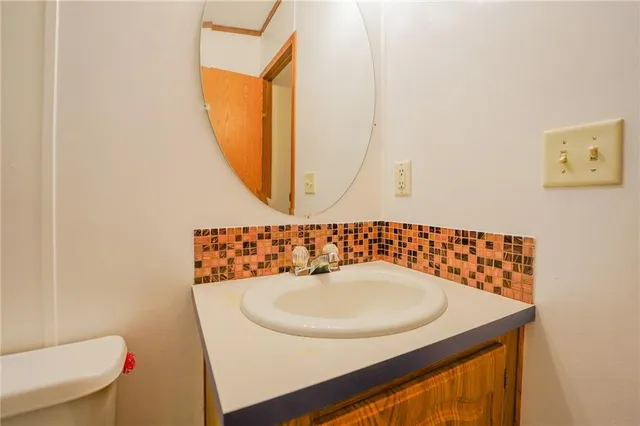 a bathroom with a toilet a sink and mirror