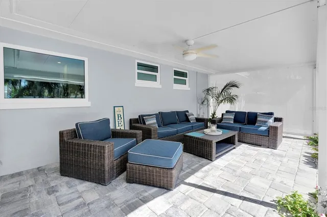 a living room with patio furniture and a floor to ceiling window