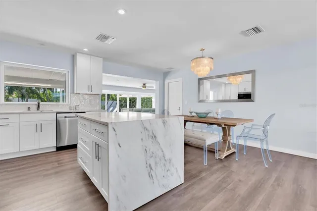 a kitchen with a refrigerator a stove a sink and chairs