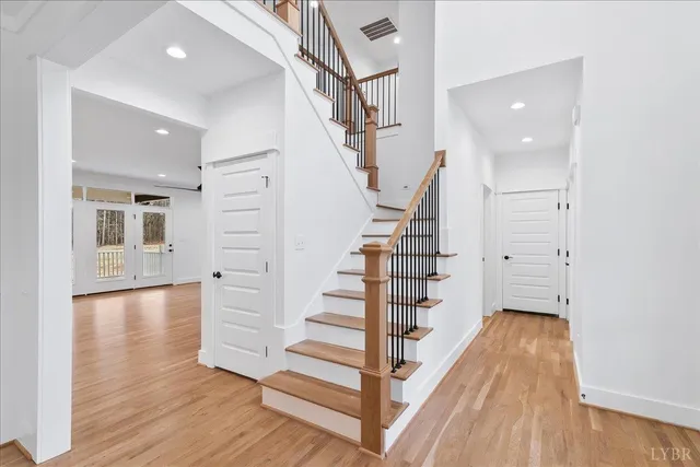 a large kitchen with stainless steel appliances kitchen island a large counter top and a wooden floor