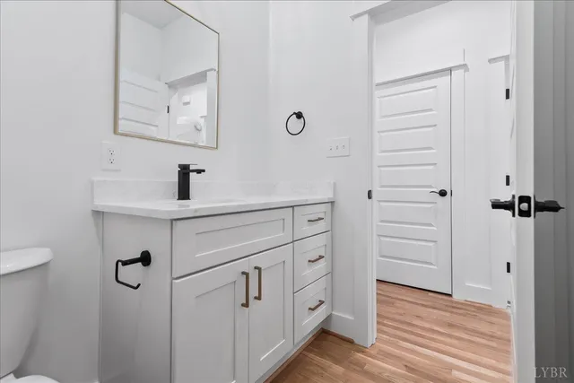 a kitchen with granite countertop white cabinets and chandelier