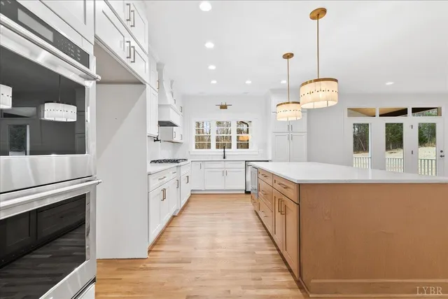 a kitchen with granite countertop white cabinets and chandelier