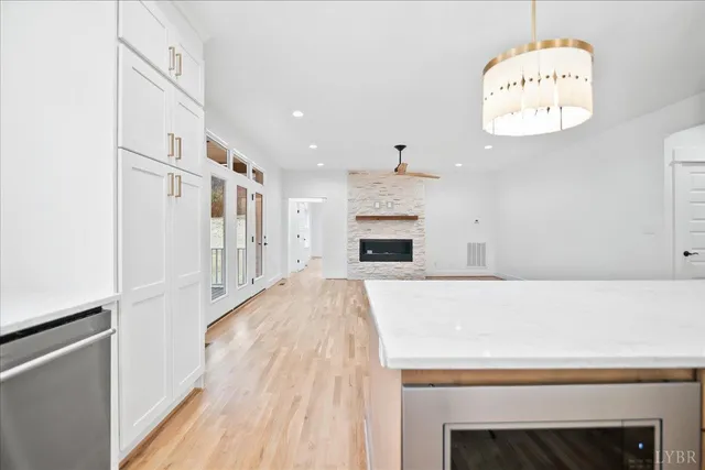 a view of an empty room with wooden floor and a fireplace
