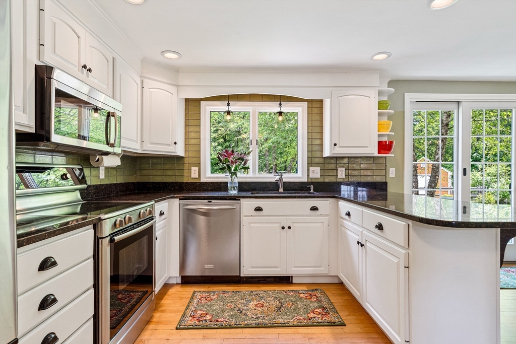 21 Boutwell Road Andover, MA 01810 - Photo 6 of 37 a kitchen with stainless steel appliances granite countertop a stove a sink and a microwave