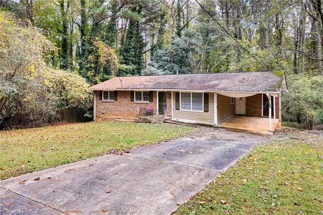 a front view of a house with a garden and trees