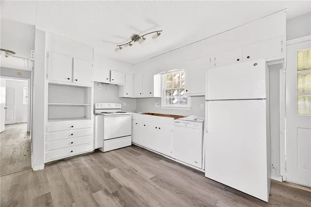 a kitchen with white cabinets and white appliances